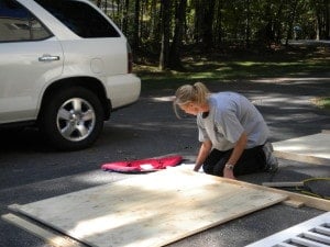 a woman working with a piece of plywood