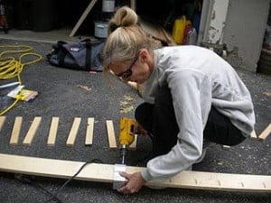 a woman drilling a piece of wood