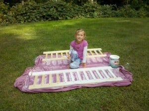 A little girl painting railings