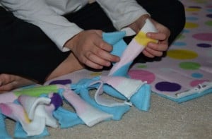 a little girl tying fabric pieces