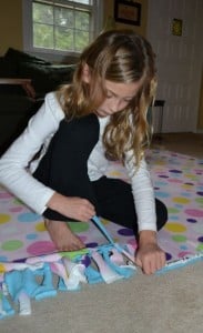 A girl tying fabric ribbons