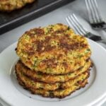 stack of four zucchini fritters on a white plate