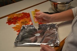 A person pouring glue onto aluminum foil