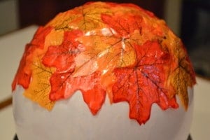 fake fall leaves glued onto a white balloon