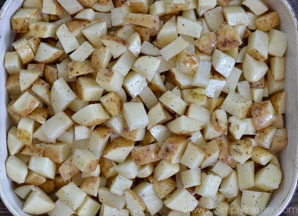 A close up of uncooked diced potatoes in a baking dish