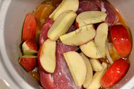 raw apple slices on top of an uncooked pork tenderloin 