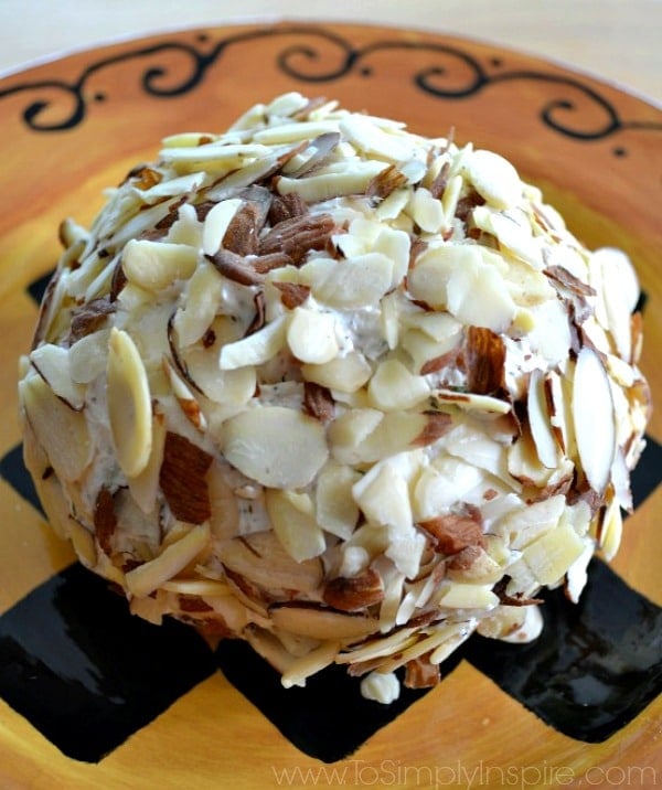 a almond covered cheeseball on a brown plate