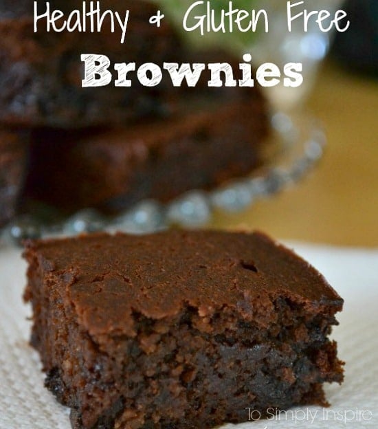 closeup of a brownie on a white napkin with a plateful of brownies in background