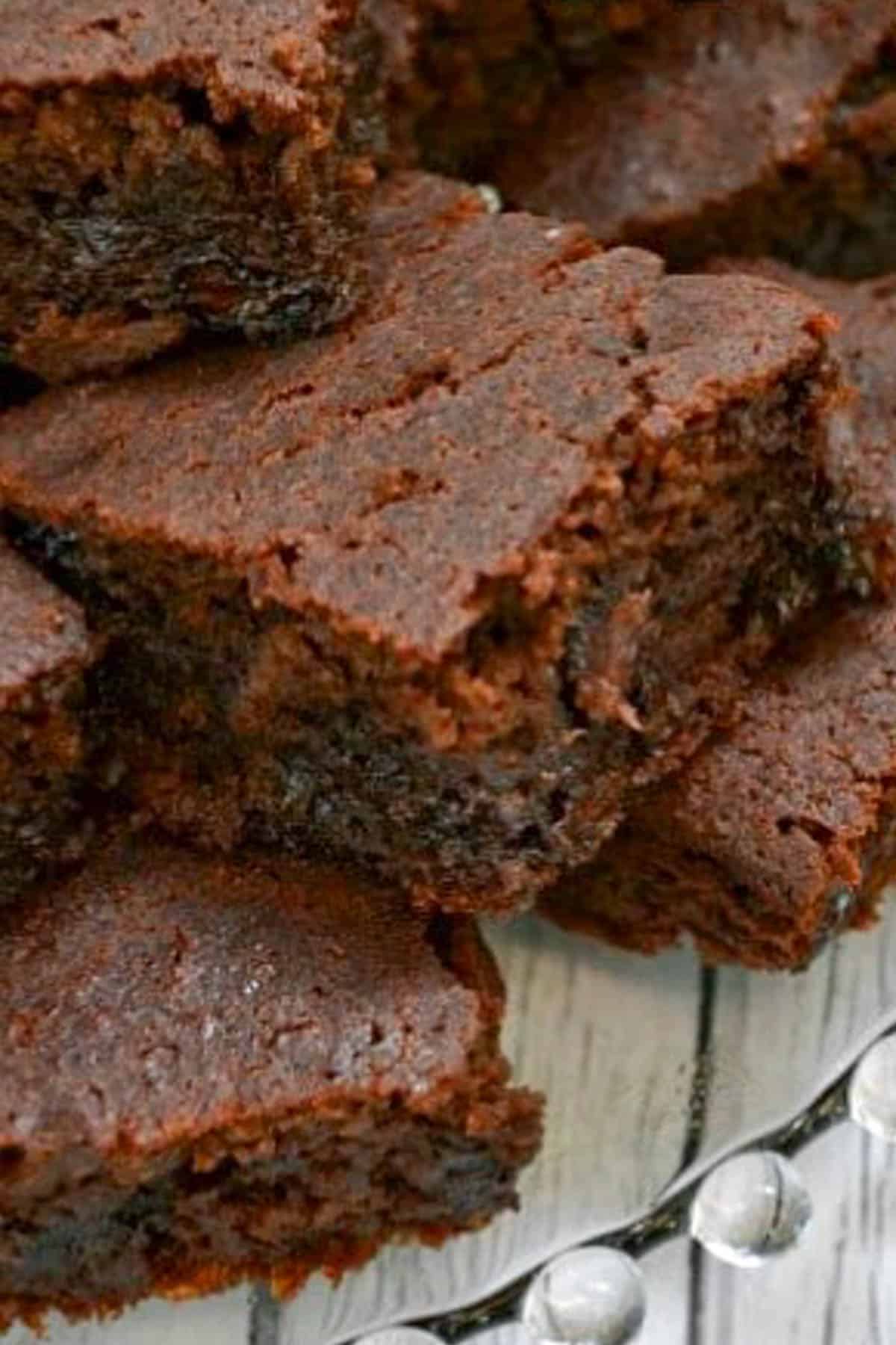 These gluten free brownies are seriously the best I have ever tasted. They are loaded with chocolatey goodness and much healthier with just a few healthy swaps. Healthy Gluten Free Brownies stacked on a plate