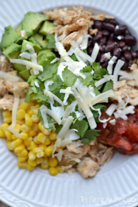 closeup of diced avocado, corn, salsa and cheese in a bowl