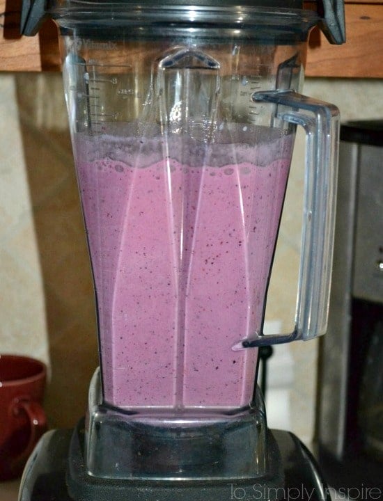 A blender filled with strawberry smoothie