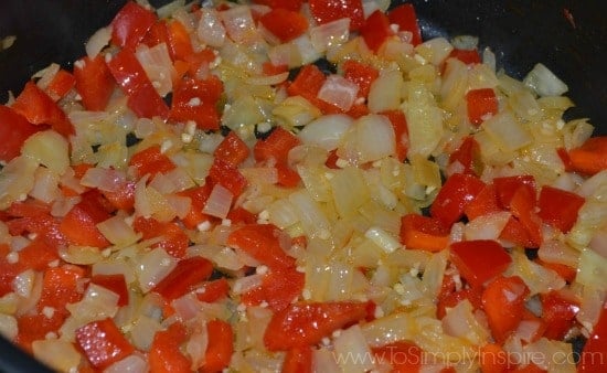 red peppers and onions sautéing in a pan 