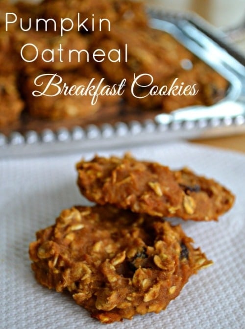 pumpkin oatmeal cookies on a white napkin with a plateful in the background 