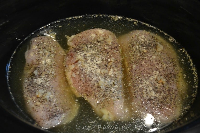 three chicken breasts in chicken broth in a crock pot