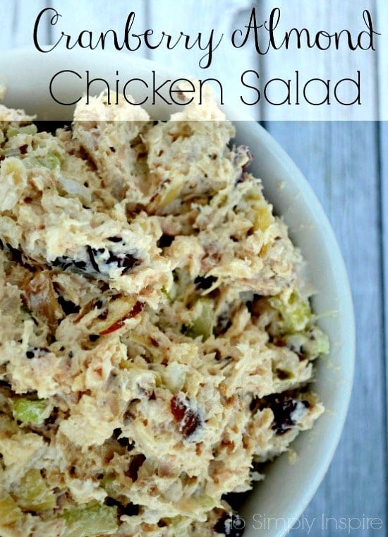 a white bowl full of chicken salad with cranberries