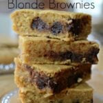 four blonde brownies with chocolate chips stack on a plate