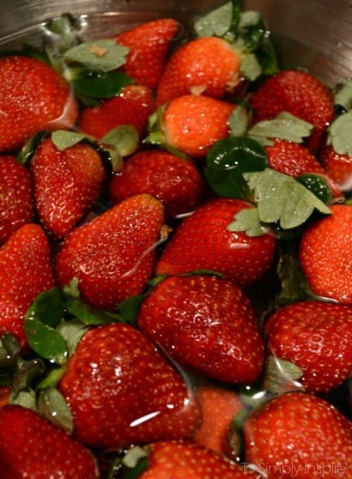 a bowl full of strawberries soaking in water