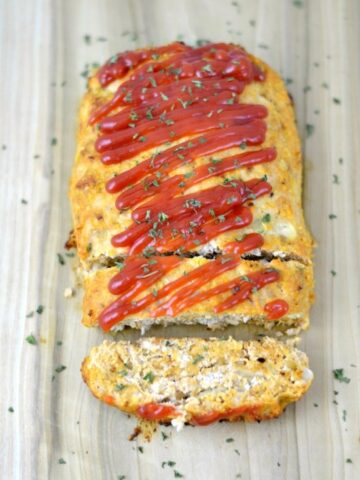 Turkey Meatloaf with tomato sauce on a wood cutting board