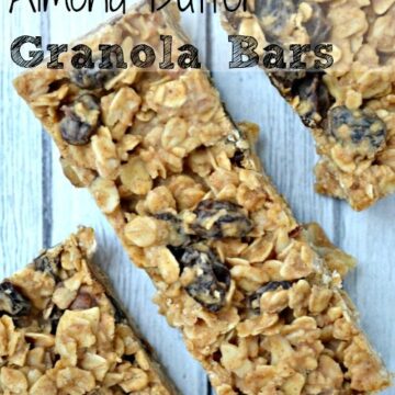 three granola bars with raisins on a grey wood table