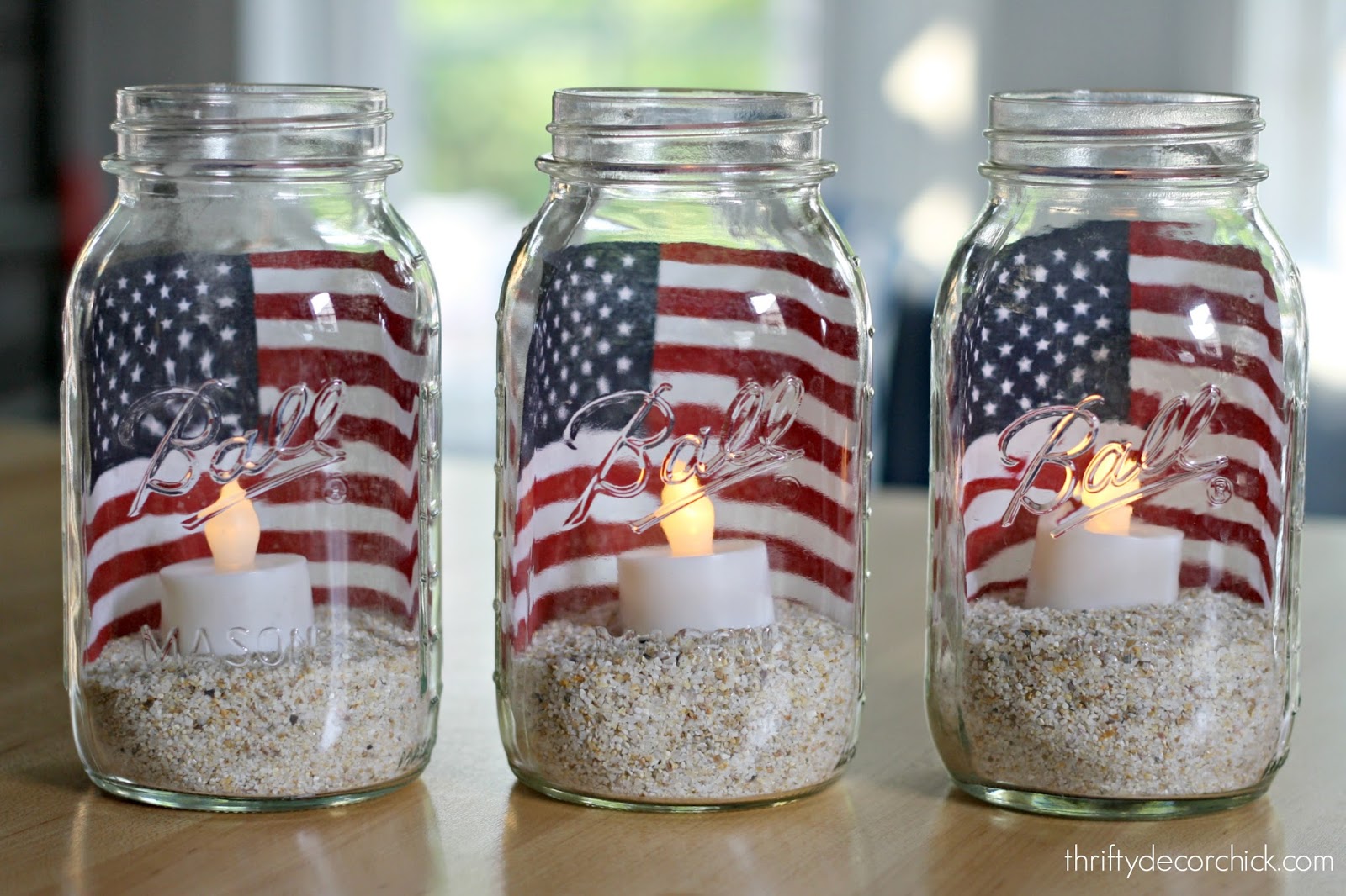 A close up of 3 bottles with small american flags in each