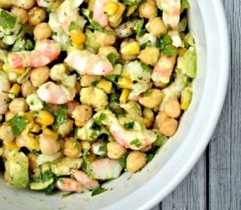 shrimp, chickpea, avocado and corn salad in a white bowl