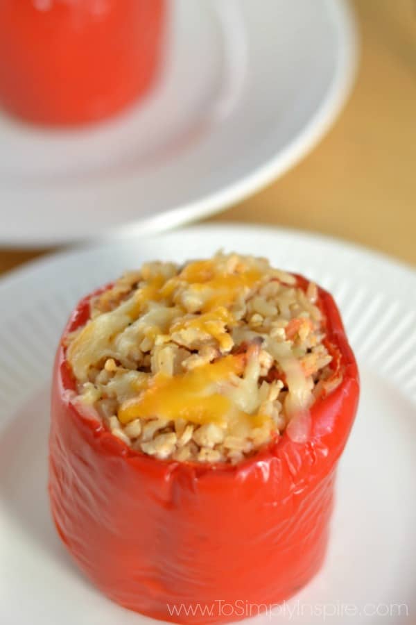 closeup of a red pepper stuffed with a mixture of brown rice, ground turkey on a white plate