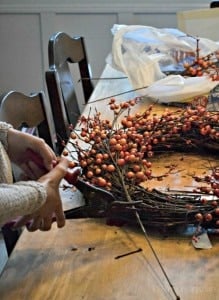 Girl cutting orange berries for a Fall Wreath