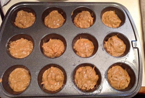 a muffin tin with carrot cake batter 