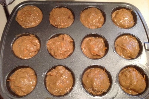 a muffin tin filled with carrot cake batter