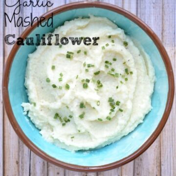 mashed cauliflower topped with scallions in a light blue bowl