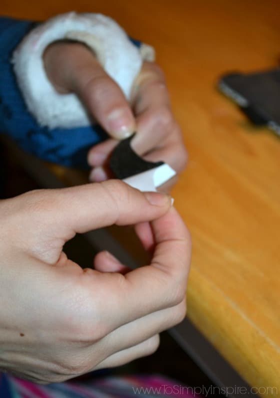 a girls hand holding black felt