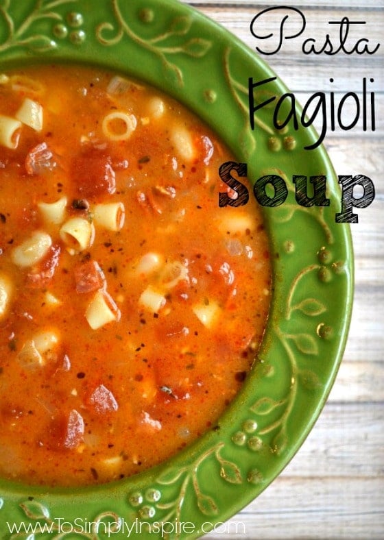 a green bowl full of tomato soup with ditalini pasta