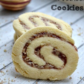 closeup of raspberry pinwheel cookie leaning against a stack