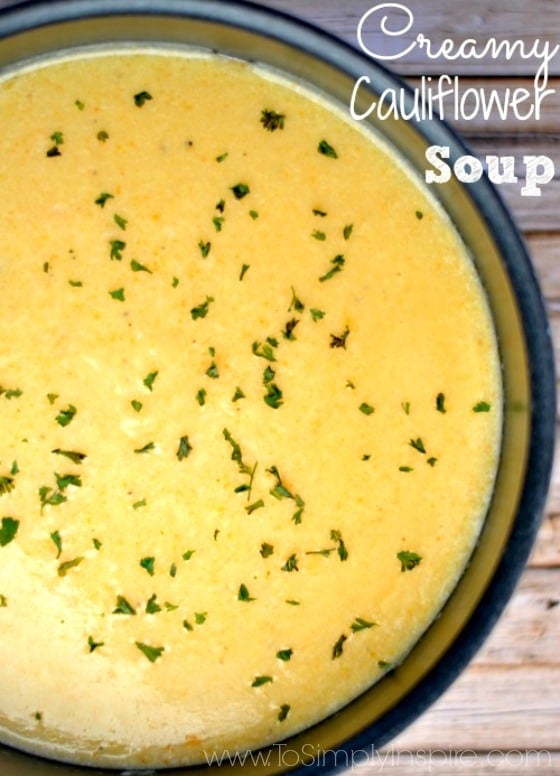 closeup of a pot of creamy Cauliflower soup topped with parsley 