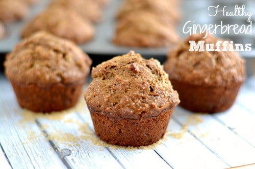 A close up of a several coffee cake muffins on a light grey wood table