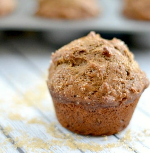 A close up of a coffee cake muffins on a light grey wood table