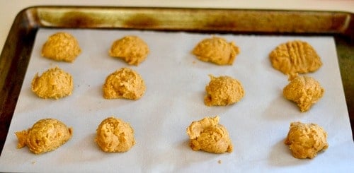 A tray of uncooked peanut butter cookies on parchment paper