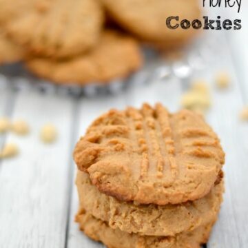 a stack of 3 peanut butter cookies with a plate in the background