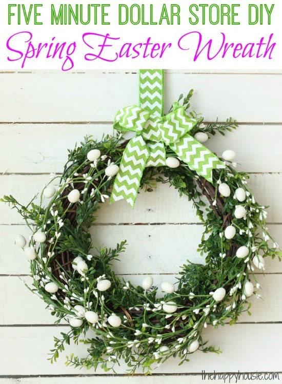 a green wreath with white easter eggs hung with a green and white ribbon