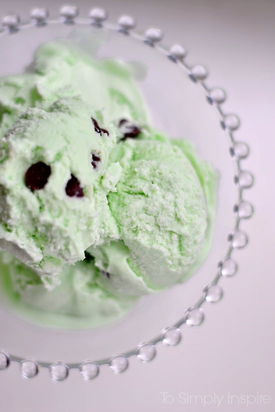 closeup of green mint chocolate chip ice cream scoops in a glass bowl