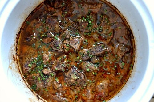 Top view of Mexican Barbacoa beef recipe cooking in a white slow cooker