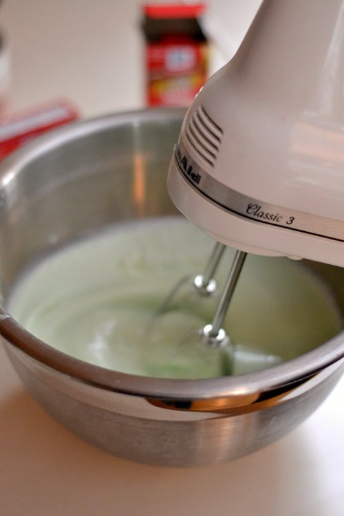 hand mixer mixing light green milk mixture