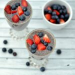 A close up of Two dishes of Chia Seed Pudding topped with strawberries and blueberries