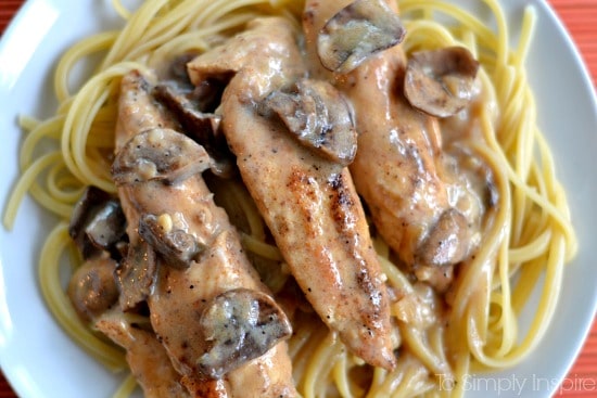 three chicken tenders in a mushroom sauce over spaghetti 