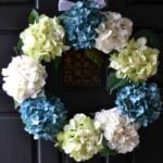 DIY spring wreath with blue green and white hydrangeas on a black door