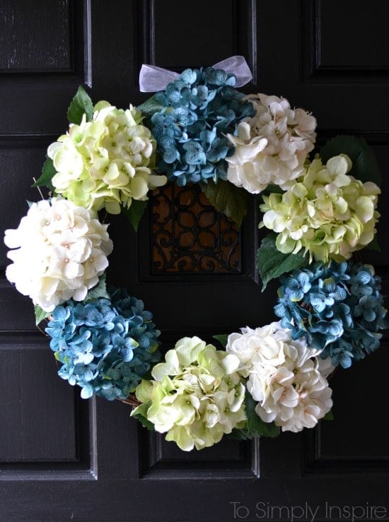 DIY spring wreath with blue green and white hydrangeas on a black door