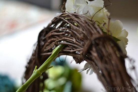 closeup of back of grapevine wreath with flower stem