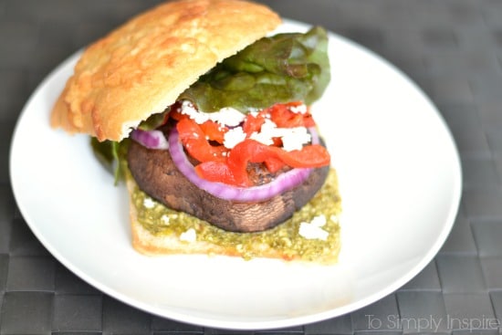 A portobello Mushroom sandwich with lettuce, red peppers and red onion slice