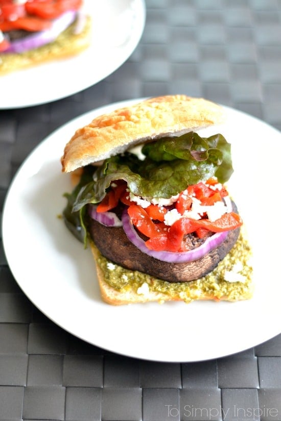 A portobello Mushroom sandwich with lettuce, red peppers and red onion slice