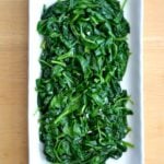 Sauteed Spinach with garlic on a white rectangle plate